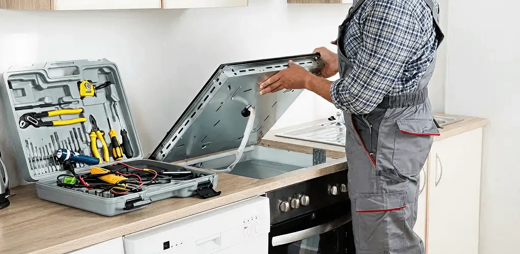 Handyman repairing a cooktop and checking wiring connections in Columbia, MO