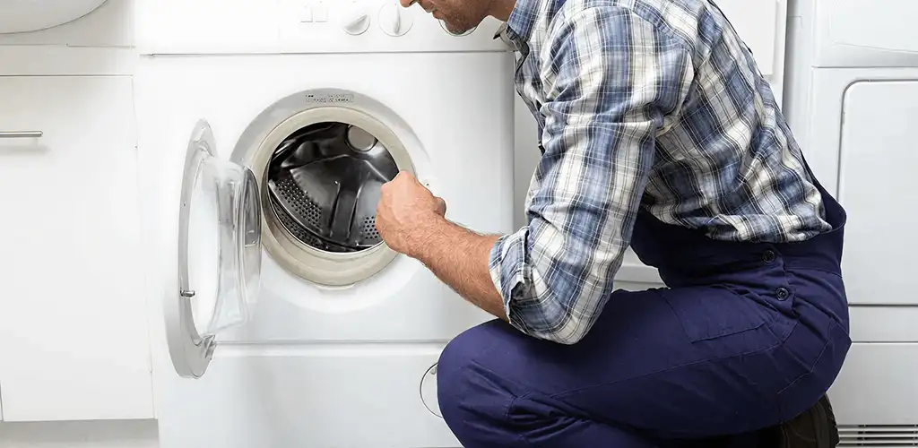 Handyman inspecting a dryer drum and internal parts for repair in Columbia, MO