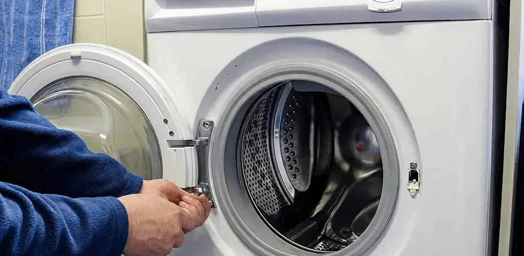 Washing machine repair handyman checking a front-load washer door and latch in Columbia, MO