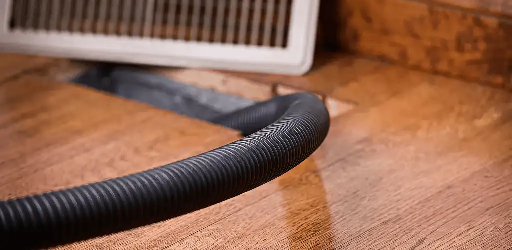 Air duct cleaning hose inserted into a floor vent for ductwork cleaning in Columbia, MO