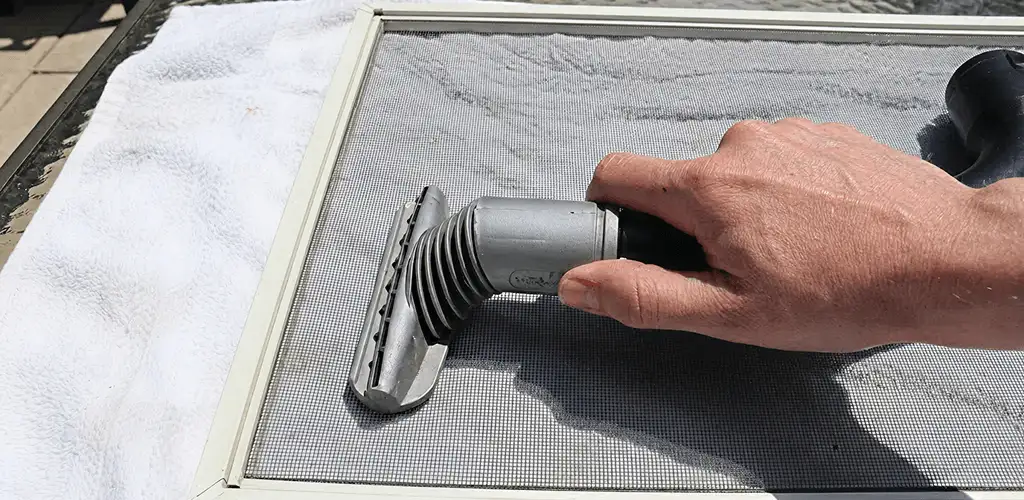 Window screen repair cleaning and fixing a damaged screen mesh in Columbia, MO